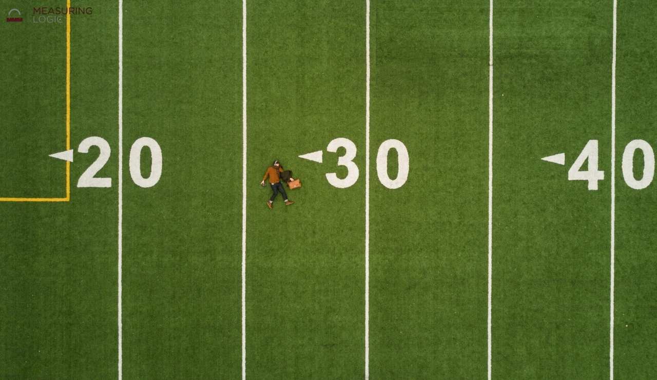 An aerial top-down view of a green American football field