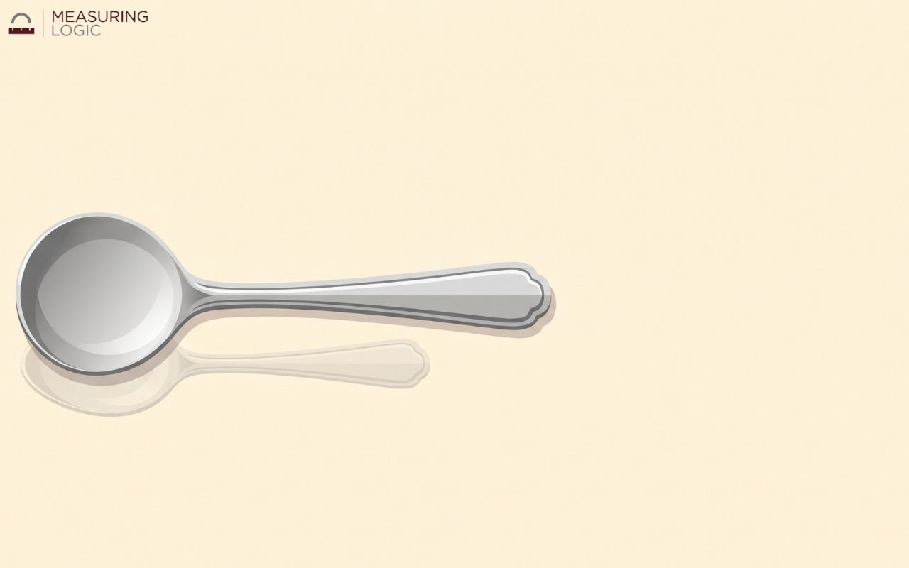 A standard silver soup spoon lying flat on a pale background