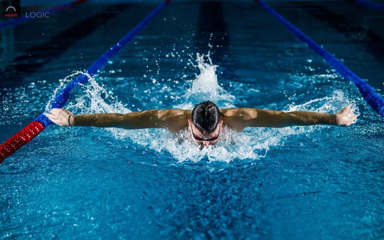 Swimmer performing butterfly stroke in a pool lane