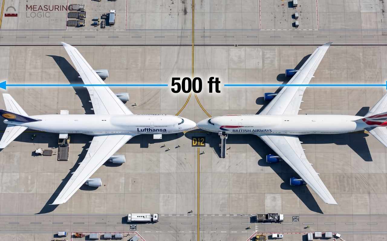 Aerial view of two parked airplanes parked nose-to-nose, spanning a combined length of 500 feet.
