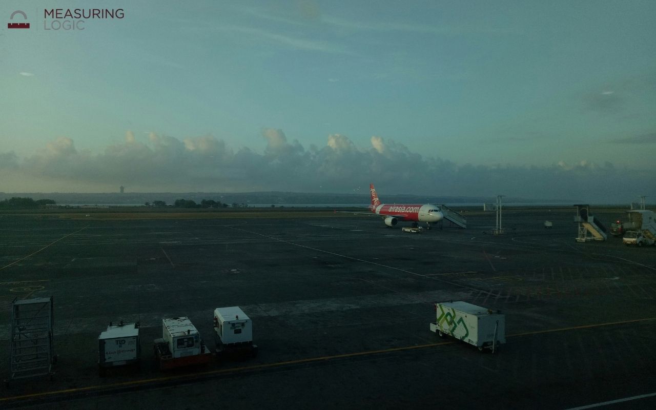 plane parked on an airport tarmac seen through a window, showing open runway distances around 500 feet